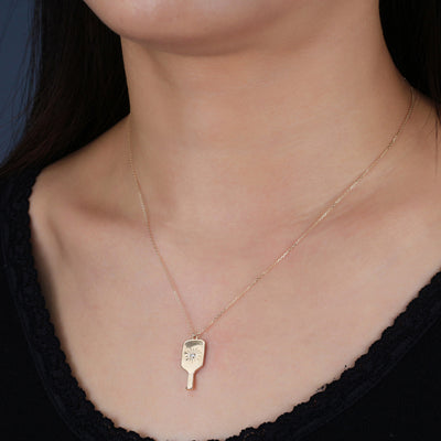 Fine Pickleball Paddle Pendant Necklace Solid 14k Gold with Diamond featuring a perfectly proportioned pickleball paddle with an impact center burst to imitate the instant the pickleball is hit. A pretty sparkling real non-farmed diamond marks the spot!