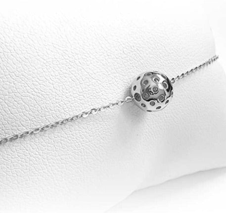 Charming Silver Baby Belle Pickleball Bracelet with Single Pickleball. This bracelet is made from sustainably sourced sterling silver. Visually accurate micro pickleball in silver, moves along our dainty 6.5" gold chain with a 2" extender.