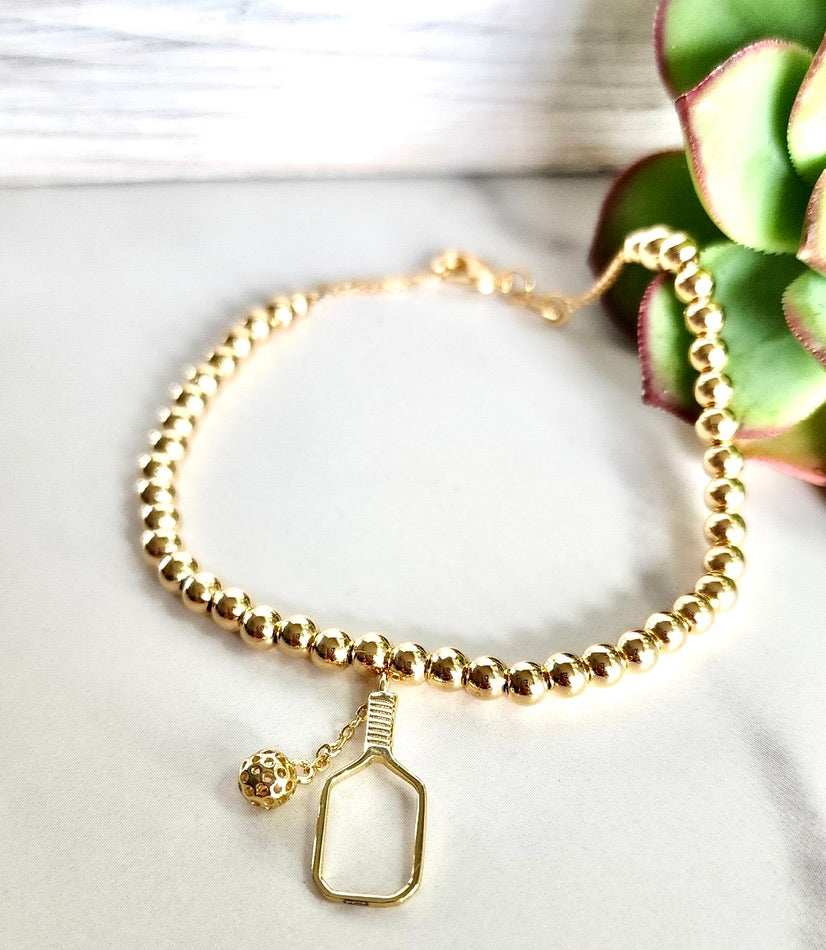 Gold-filled bead ball bracelet. 7.25" with a lobster clasp, 4mm diameter beads and comes with branded microsuede pouch. Wear as is or add in any of our themed charms for added wow factor.