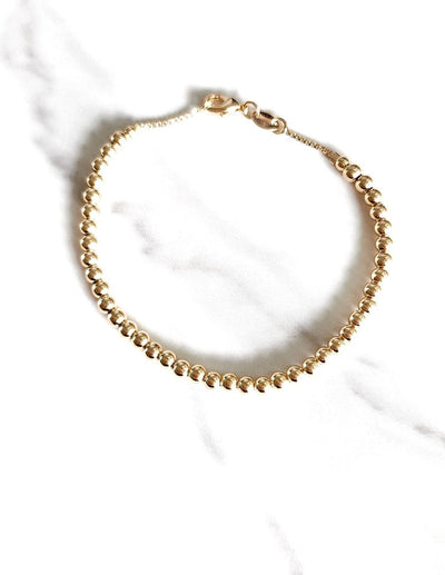 Gold-filled bead ball bracelet. 7.25" with a lobster clasp, 4mm diameter beads and comes with branded microsuede pouch. Wear as is or add in any of our themed charms for added wow factor.