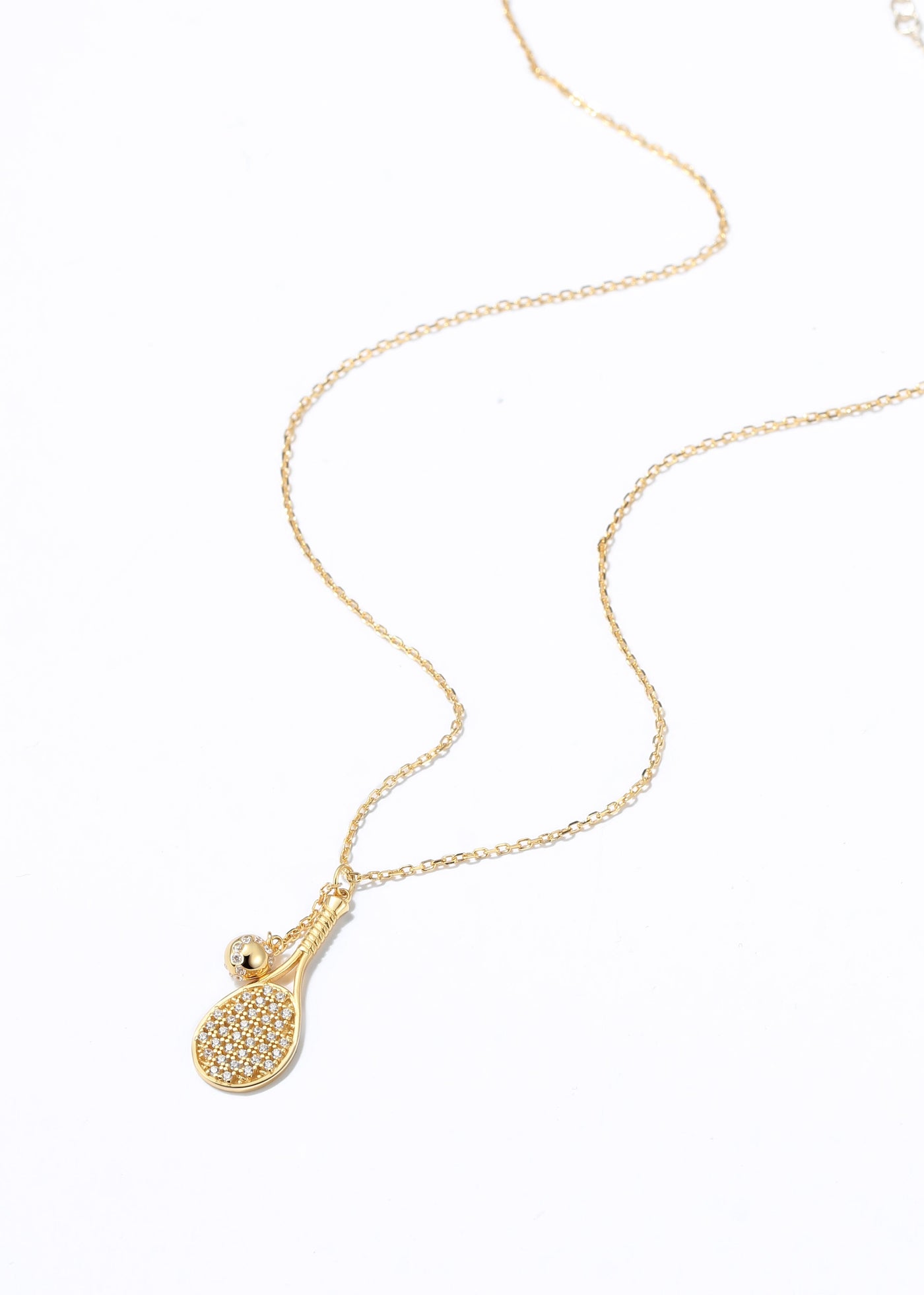 LoveMatch Gold Tennis LOVE PLUS Dainty Necklace featuring a detailed tennis racket, then added a tennis ball on a chain to 'swing' with every step, added some sparkling crystals for extra bling!